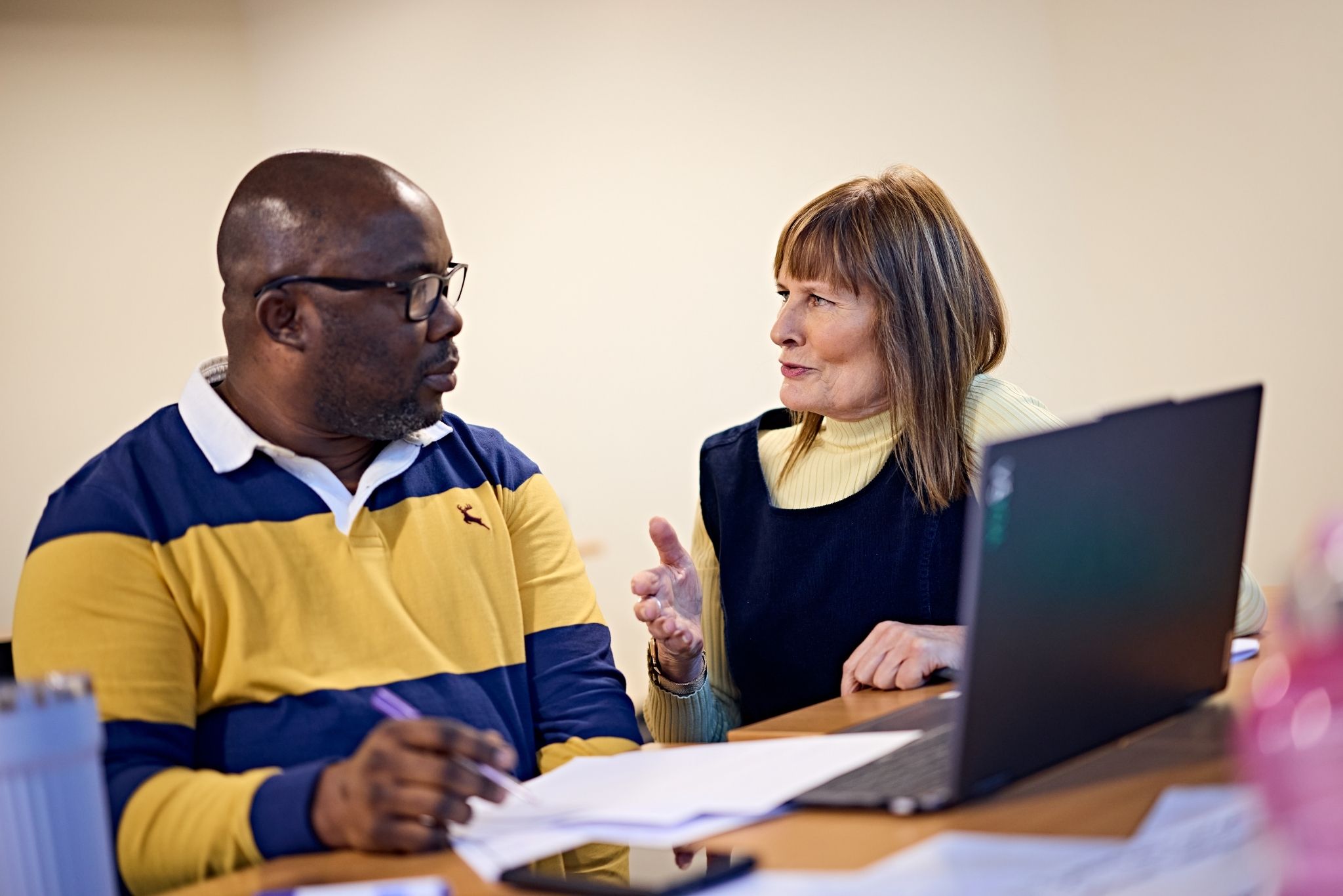 Two academics having a discussion with a laptop