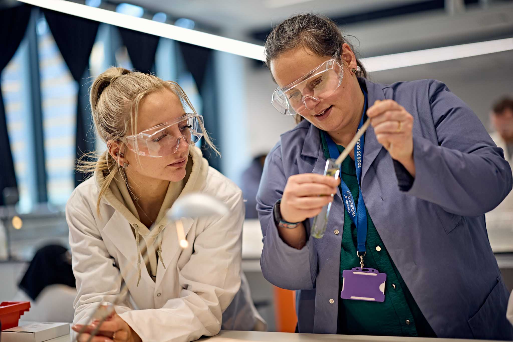 Science teacher performing a chemical experiment for a student