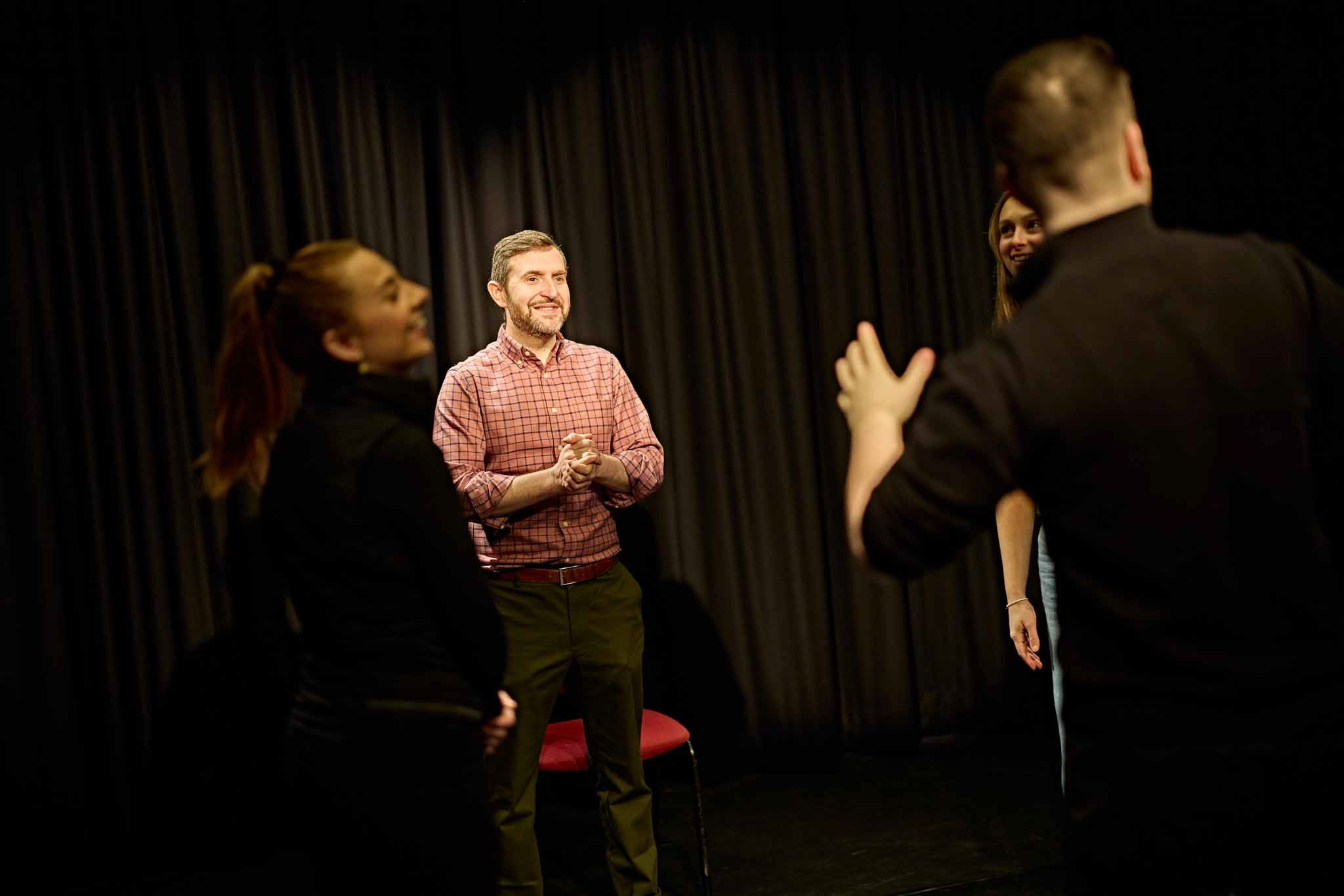 Drama students and teacher in a performing arts space