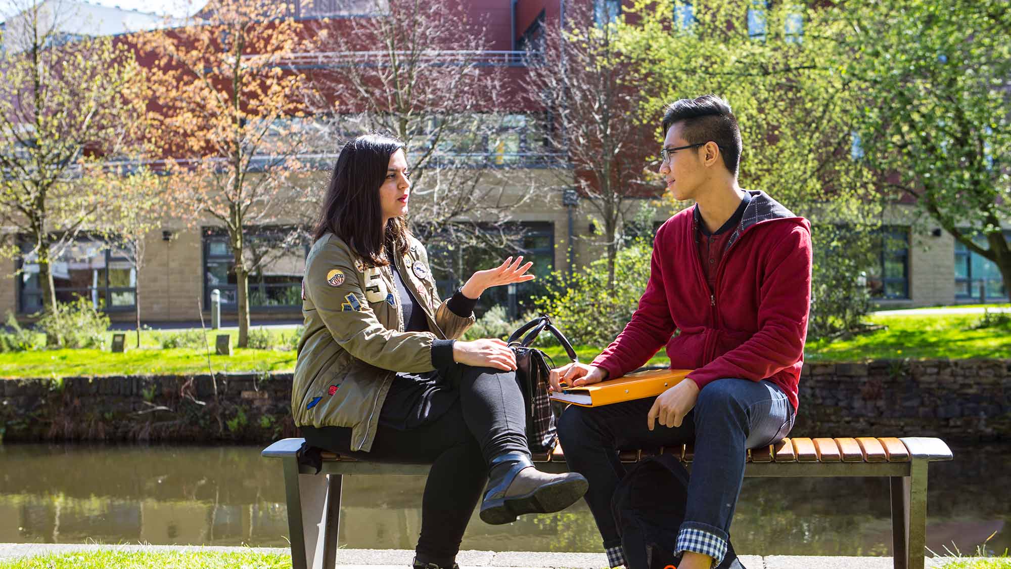 Students sat together on the banks of the canal on campus. 