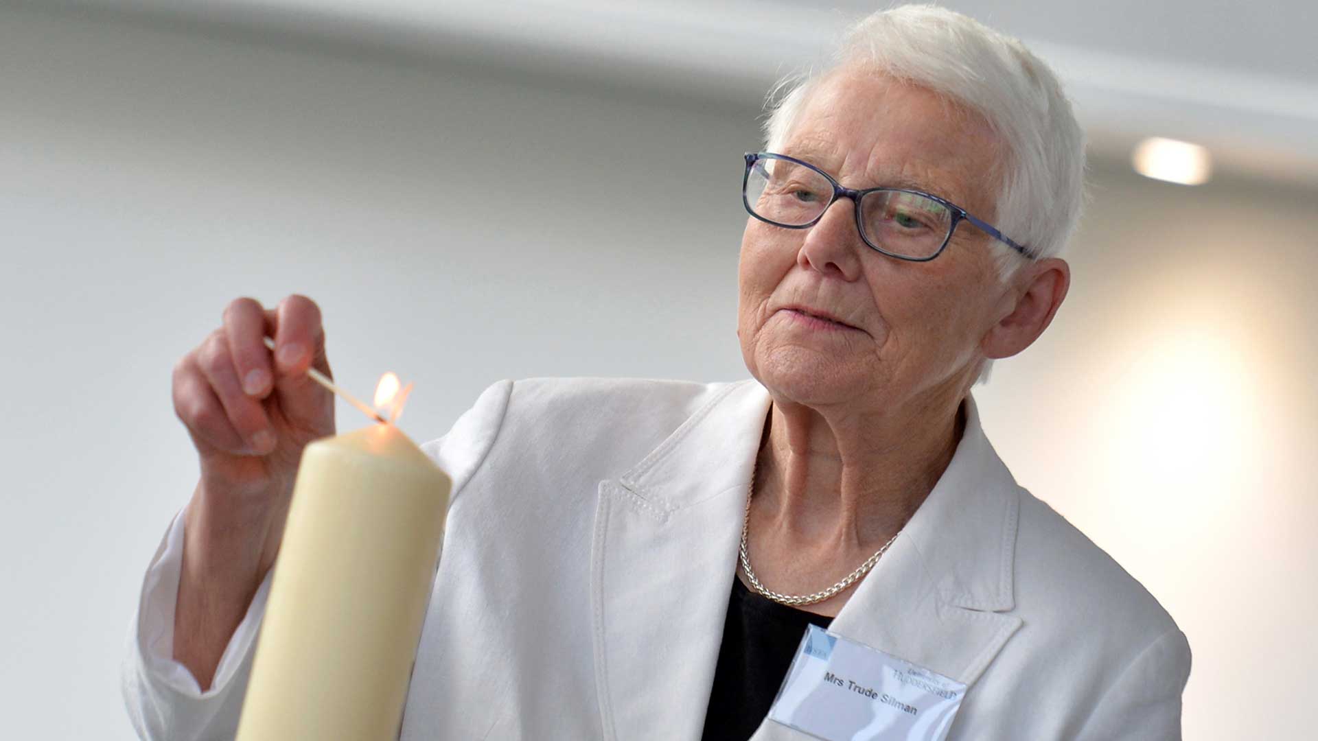 Holocaust survivor Trudie Silman lights the candle for the ceremony