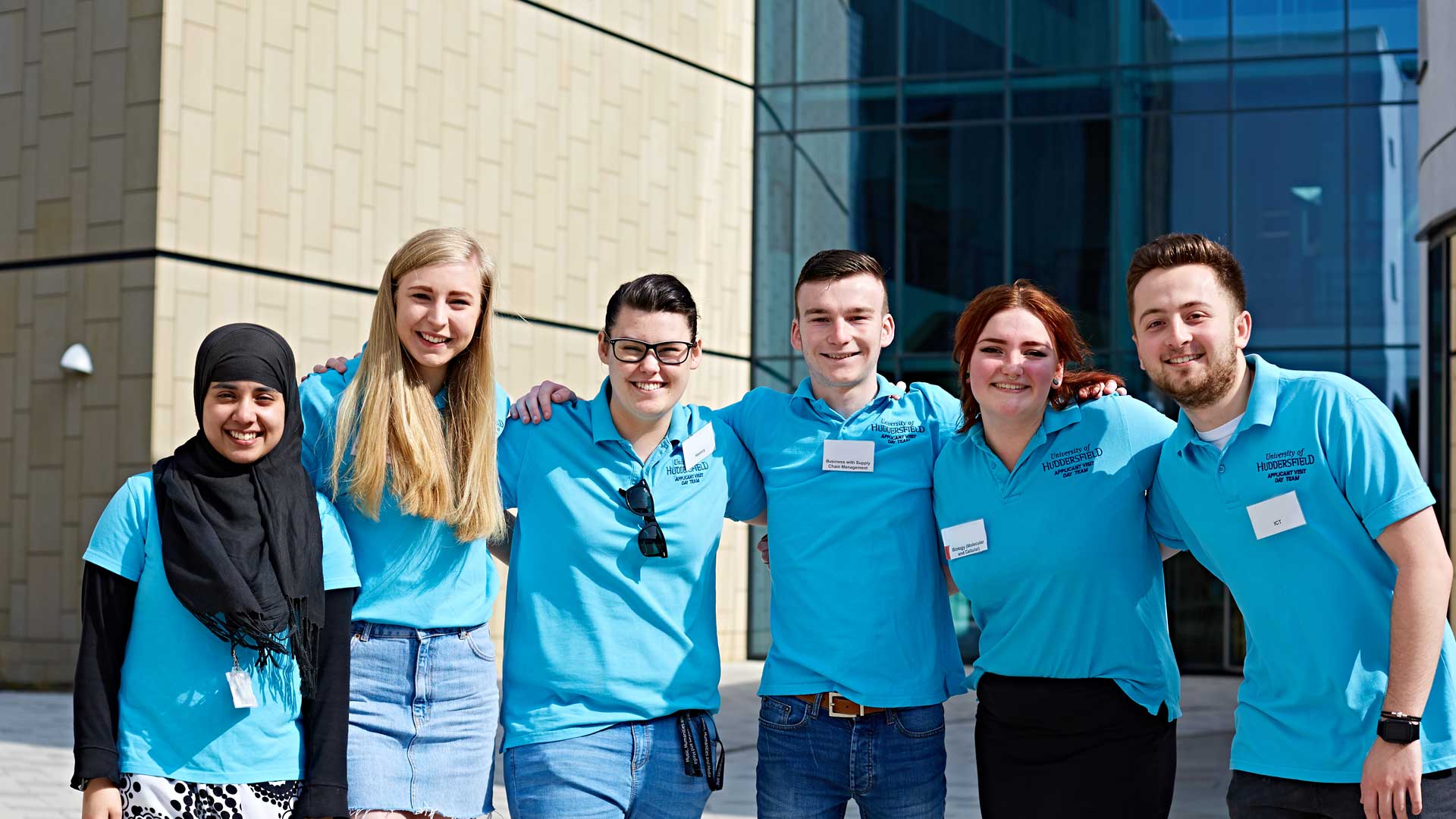 Picture of student ambassadors at an avd. They're linking arms and looking at the camera.