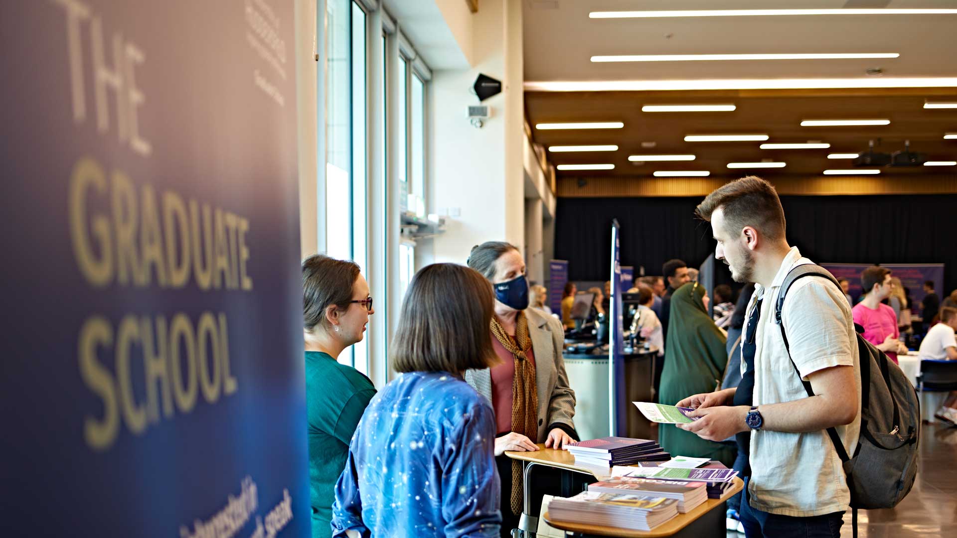 Graduate school banner and people talking