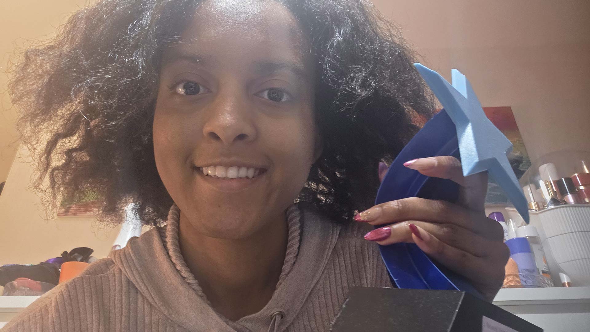 Acacia smiling and holding a trophy.