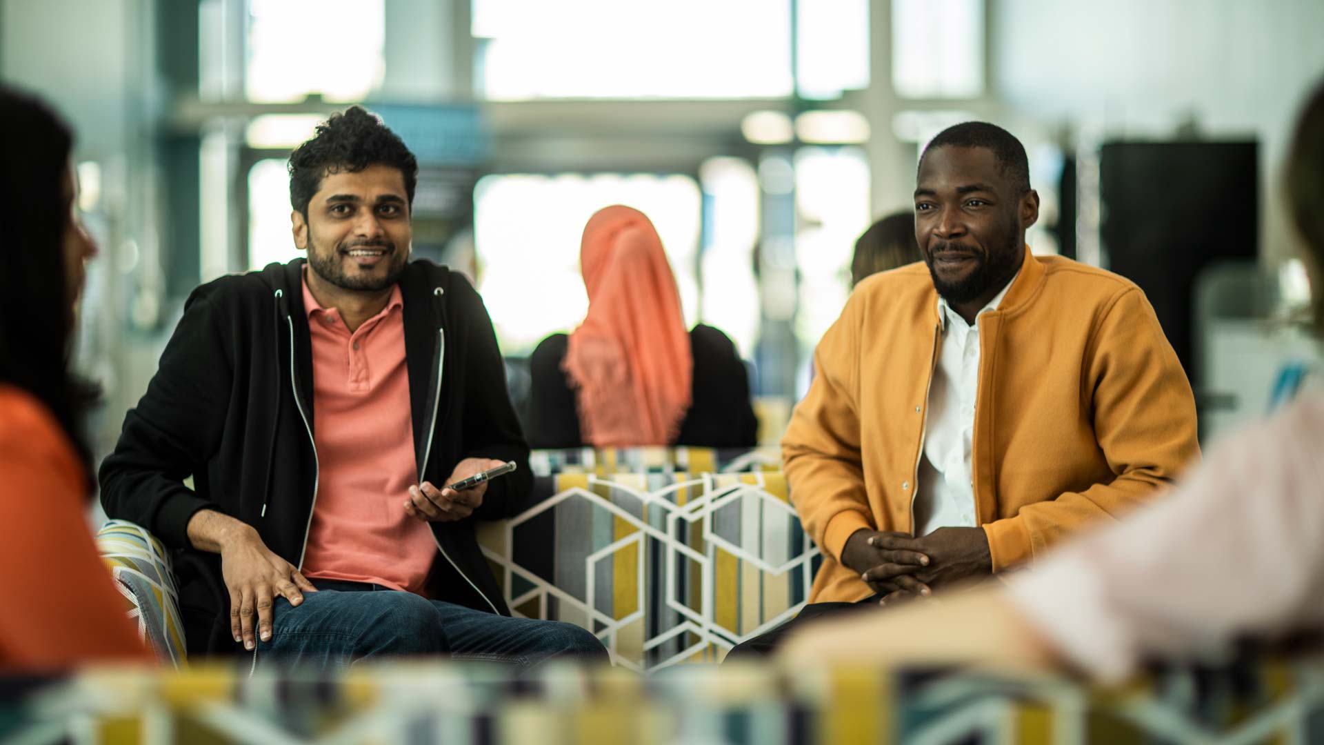 a photo of students chatting on a sofa